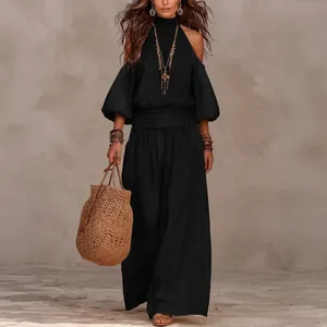 Elegante conjunto de top halter negro con mangas abullonadas y pantalón de pernera ancha.