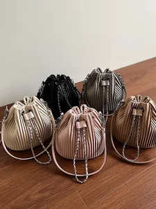 Collection of five stylish pleated drawstring bucket bags with chain straps in neutral tones