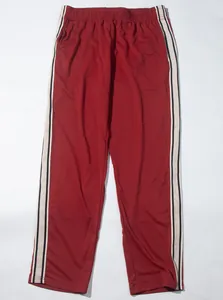 Detailansicht der Stoffstruktur und Seitenstreifen der dunkelroten Herrensporthose.