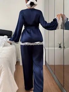 Elegantes marineblaues Satin-Pyjama-Set mit weißer Spitze, Rückansicht im Schlafzimmer