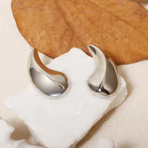 Détail macro de boucles d'oreilles gouttes argentées avec une finition miroir polie.
