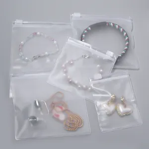 Detail macro view of frosted transparent jewelry zipper bags containing necklaces and earrings