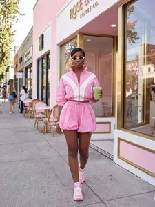 Stylish pink and white color-block two-piece lounge set worn by a model in a street setting.