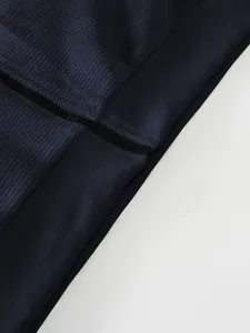 Detailed close-up of navy blue pineapple grid texture fabric and zipper on men's jacket
