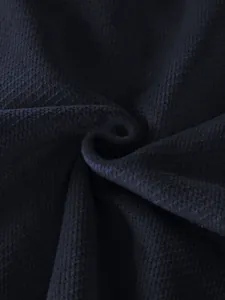 Macro view of navy blue pineapple grid fabric showing high-quality knitted texture.