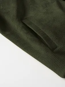 Macro shot of deep green pineapple knit texture on a men's thickened cardigan jacket.