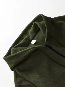 Close-up of men's dark green hooded jacket showing pineapple grid texture and tag