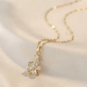Elegante collar con colgante de molino de viento giratorio y circonitas en oro.