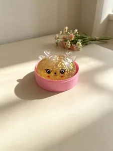 Detailansicht eines Rentier-Stressspielzeugs mit Goldglitzer in einer rosa Box