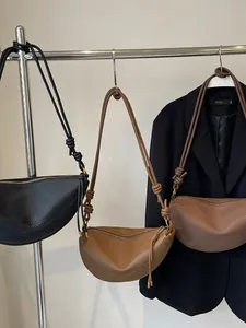Minimalistische retro crossbodytas van kiezelleder met geknoopte schouderbanddetails