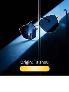 Close-up of rimless polygonal sunglasses with blue lenses and gold metal details