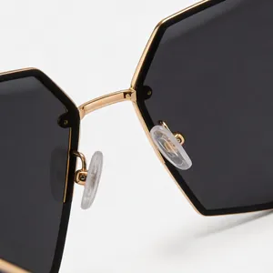 Close-up of metal polygon sunglasses with gold frame and comfortable nose pads.