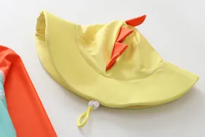 Detailed view of yellow children's sun hat with orange dinosaur spikes