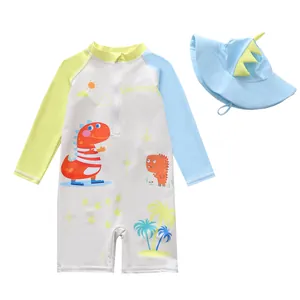 Detail of boys one-piece long sleeve swimsuit with dinosaur print and matching hat