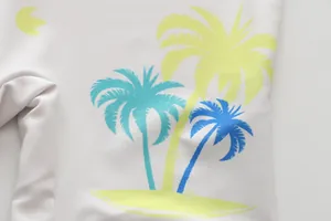 Close-up detail of tropical palm tree print on boys' one-piece swimsuit fabric