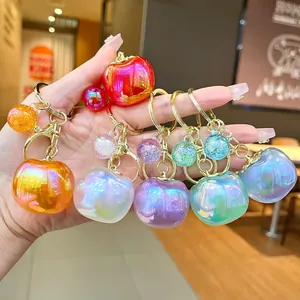 Close-up showing various colorful iridescent pearlescent apple-shaped keychains