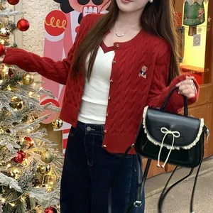 Rote Strickjacke mit Zopfmuster und Bärenstickerei für einen festlichen Weihnachtslook.