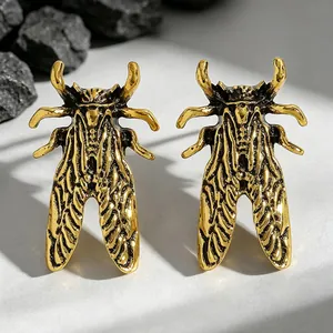 Macro detail view of a vintage golden beetle ring with intricate insect wing textures.