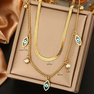 Detail shot of 18K gold plated double-layer necklace featuring blue evil eye charms