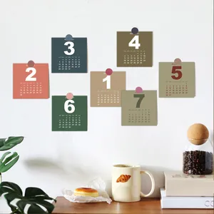 Detailed view of minimalist 2027 colorful square calendar cards pinned on a wall