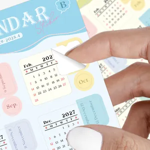 Macro detail of peeling a colorful 2027 monthly calendar sticker for daily planner