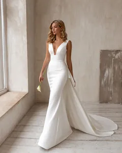 Vue détaillée d'une robe de mariée blanche sans manches avec col en V profond et traîne.