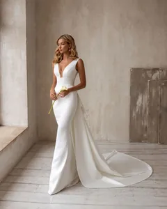 Robe de mariée élégante blanche à col en V sans manches avec une longue traîne fluide