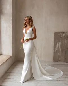 Robe de mariée blanche élégante sans manches avec col en V et longue traîne dans un studio