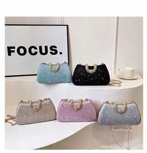 Detailansicht von fünf glitzernden Abendtaschen in verschiedenen Farben mit Strassgriff.