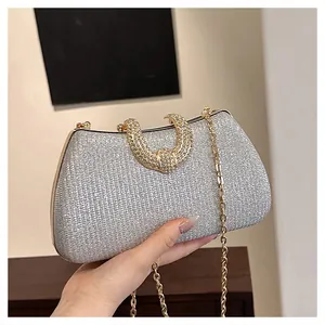 Detailansicht der silbernen Glitzer-Abendclutch mit elegantem Strassgriff und Goldkette