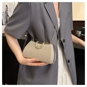 Elegante champagner goldene Glitzer-Abendtasche mit Kette, getragen zu einem grauen Blazer