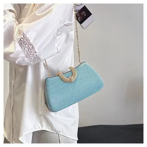 Detailansicht einer glitzernden blauen Abendhandtasche mit einem eleganten Kristallgriff.