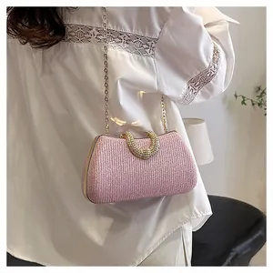Detailaufnahme einer eleganten rosa Glitzer-Abendtasche mit hufeisenförmigem Griff