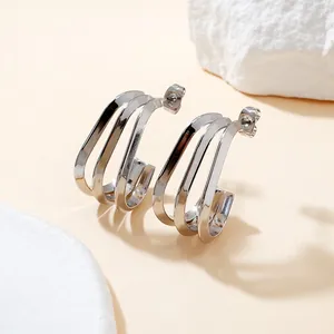 Macro view showing sleek triple-row design of silver titanium steel hoop earrings