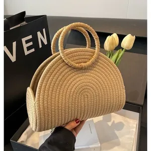 Gedetailleerde close-up van een stijlvolle beige gevlochten handtas voor zomerse stranddagen.
