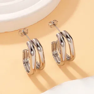 Macro detail showing the smooth silver finish of titanium steel double geometric hoop earrings