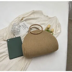 Handgemaakte gevlochten strooien handtas voor strandstijl in lifestyle flat lay.
