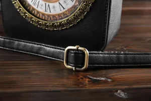 Detailansicht des schwarzen Vintage-Uhr-Taschenriemens mit antiker Bronzeschnalle