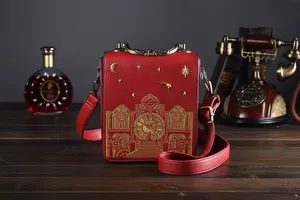 Detail einer roten Vintage-Handtasche mit goldener Stickerei und Retro-Requisiten
