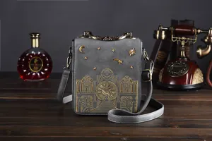 Detailaufnahme einer grauen Vintage-Umhängetasche mit goldener Uhren-Stickerei