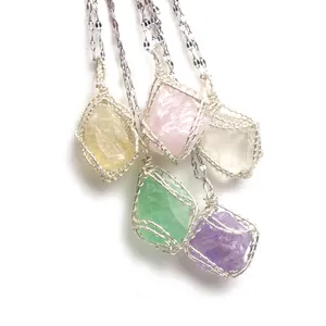 Macro view of five colorful wire-wrapped raw natural stone pendants on silver chains
