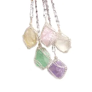Macro detail of handmade silver wire-wrapped raw natural crystal pendants in various colors