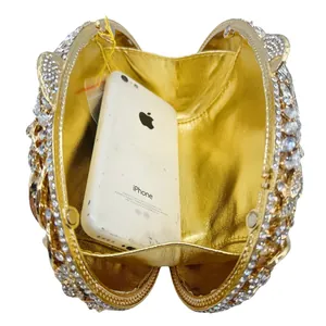 Luxurious gold evening clutch bag with sparkling crystal details showing interior space