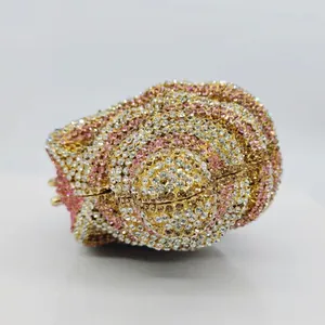 Detailed close-up of a conch-shaped evening clutch bag adorned with pink and gold crystals.