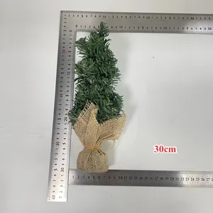 Close-up of a 30cm small artificial Christmas tree with a burlap base for decor
