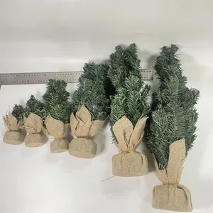 Detailed view of six miniature Christmas trees in different sizes with rustic burlap bases