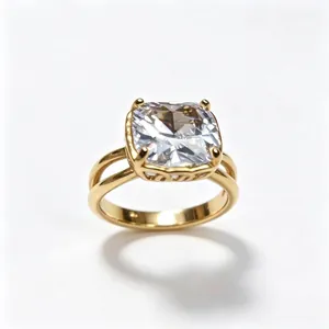 Primer plano de un anillo de acero inoxidable dorado con una gran piedra cuadrada