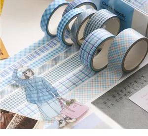 Detailopname van blauwe geruite washi-taperollen en stickers voor DIY-scrapbooking