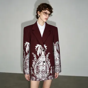 Oversized burgundy blazer with ornate silver paisley foil printing worn by a model