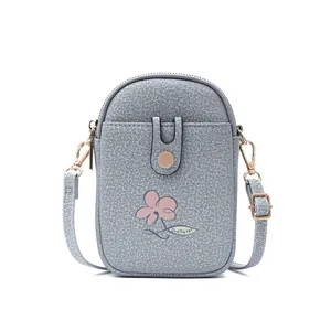 Detaillierte Vorderansicht einer grauen vertikalen Handytasche mit Blume und Goldbeschlägen